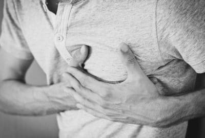 Man clutching his chest. Featured image for podcast episode "How do you mend a broken heart?"