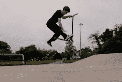 Sebastian performing a scooter trick in a skate park