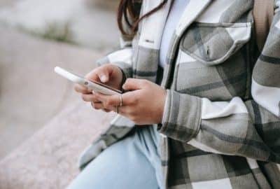 Woman looking at a mobile phone. Featured image for podcast episode "Why do we develop bad habits?"