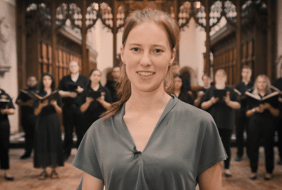 Demi Brizee stands in front of the Westminster College Choir from Rider University.