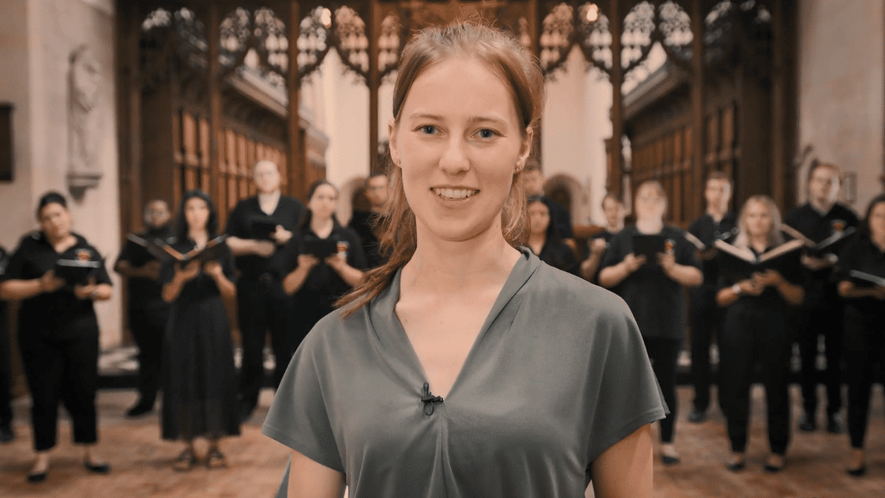 Demi Brizee stands in front of the Westminster College Choir from Rider University.