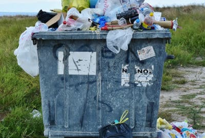 Plastic rubbish over-flowing out of a bin.