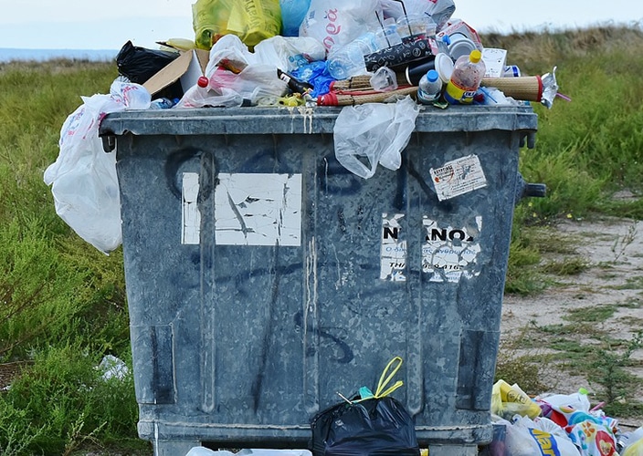 Plastic rubbish over-flowing out of a bin.