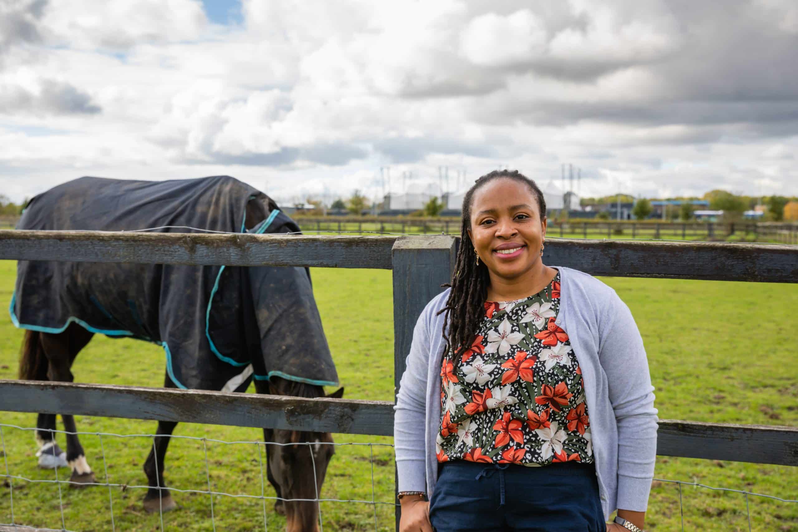 Chioma Achi profile image: Chioma standing next to a grazing horse.
