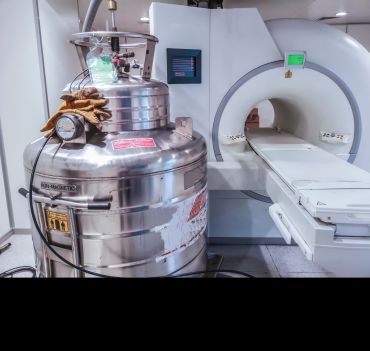 A helium gas canister next to an MRI scanner