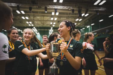 Photo of Morgan and teammates holding a trophy following a sporting game