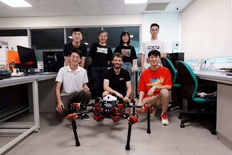 Photo of Zhiyao (bottom left) with his lab mates and a 6-legged walking robot at MARMOTLAB, National University of Singapore, 2020