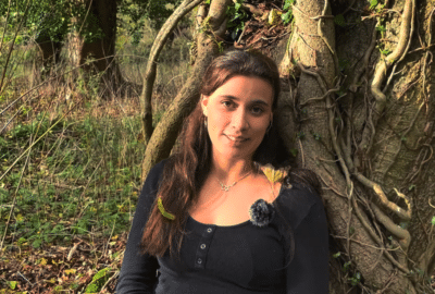 Charlotte Collingwood sits against a tree. Featured image for the video 'When Stress Turns Bad'.