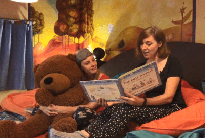 Emma and Nicky reading a book at the Story Museum in Oxford. Featured website image for the video 'A Book at Bedtime'.