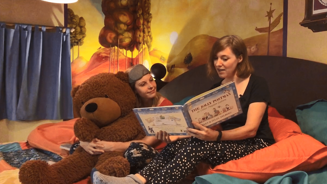 Emma and Nicky reading a book at the Story Museum in Oxford. Featured website image for the video 'A Book at Bedtime'.