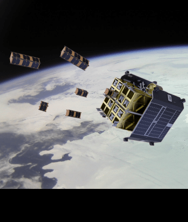 A larger square satellite in orbit above the Earth ejects several smaller satellites into outer space.