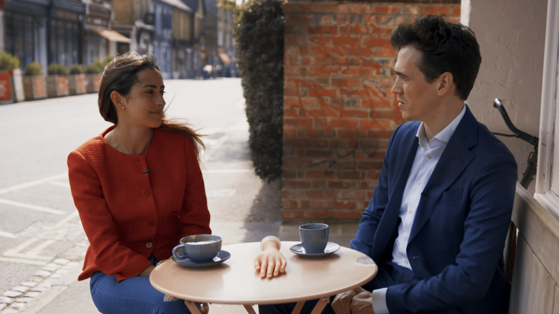 Eugenia and Fabian talk over a cup of coffee. Featured website image for the video "Code-Based Colleagues".