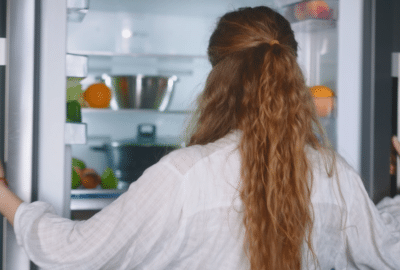A woman opens a fridge. Featured image for the video "The Brains Behind Your Breakfast".