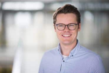 A portrait photograph of Professor Anders Kock, a white man with short brown hair, wearing glasses and a blue shirt.