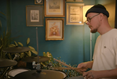 A man is sat playing drums for the Life Without Music documentary