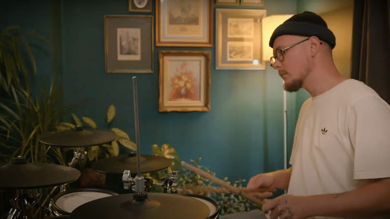 A man is sat playing drums for the Life Without Music documentary