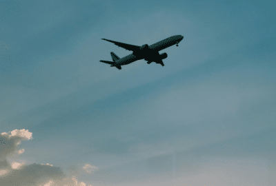 Silhouette of an aeroplane taking off, against a blue sky.